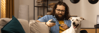 person holding credit card on couch with dog