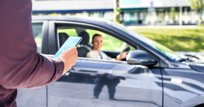 A man uses his phone to order a rideshare service. 