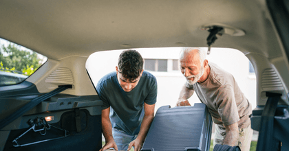 senior helping grandchild load car