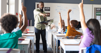 Teacher with students with hands raised