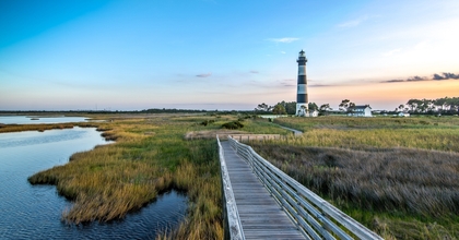 North Carolina outer banks showing lighthouse in background and bridge next to water in foreground