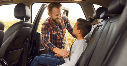 Dad buckling his son in the car