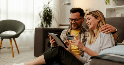 Couple using credit card on tablet