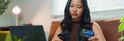 Woman looking at two credit cards