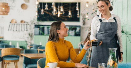 Woman using credit card at restaurant