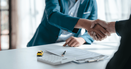 Car insurance agent shaking hands over contract