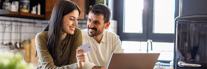 Couple using credit card on laptop