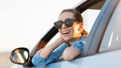 person-leaning-out-of-car-window-smiling