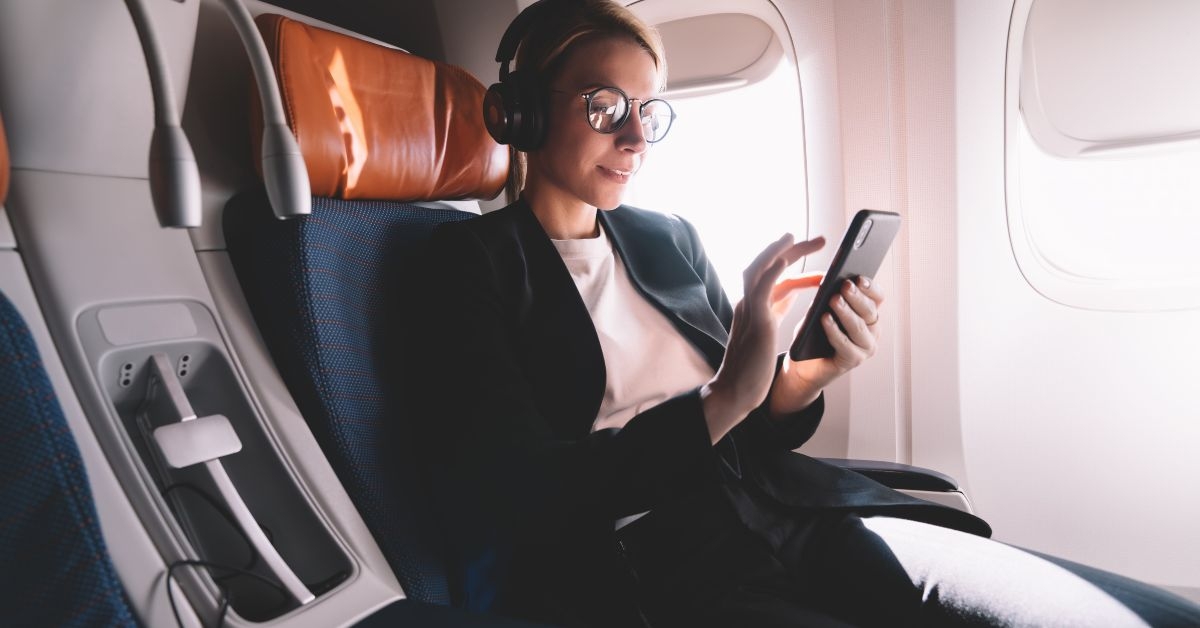 Woman sitting in business class using phone