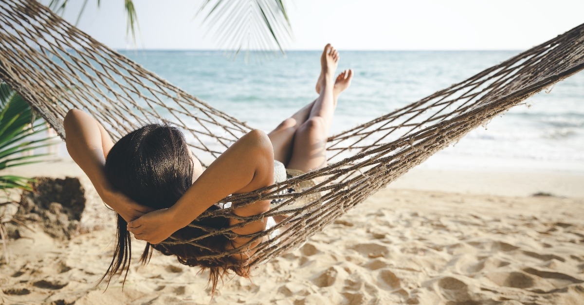 woman relaxing in hammock at beach