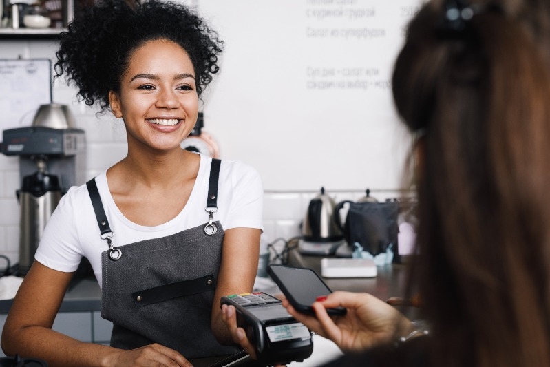 Customer paying with her mobile phone at a small cafe