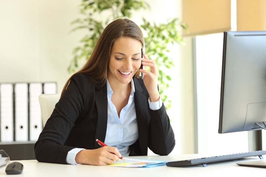 Businesswoman calling on phone and taking notes