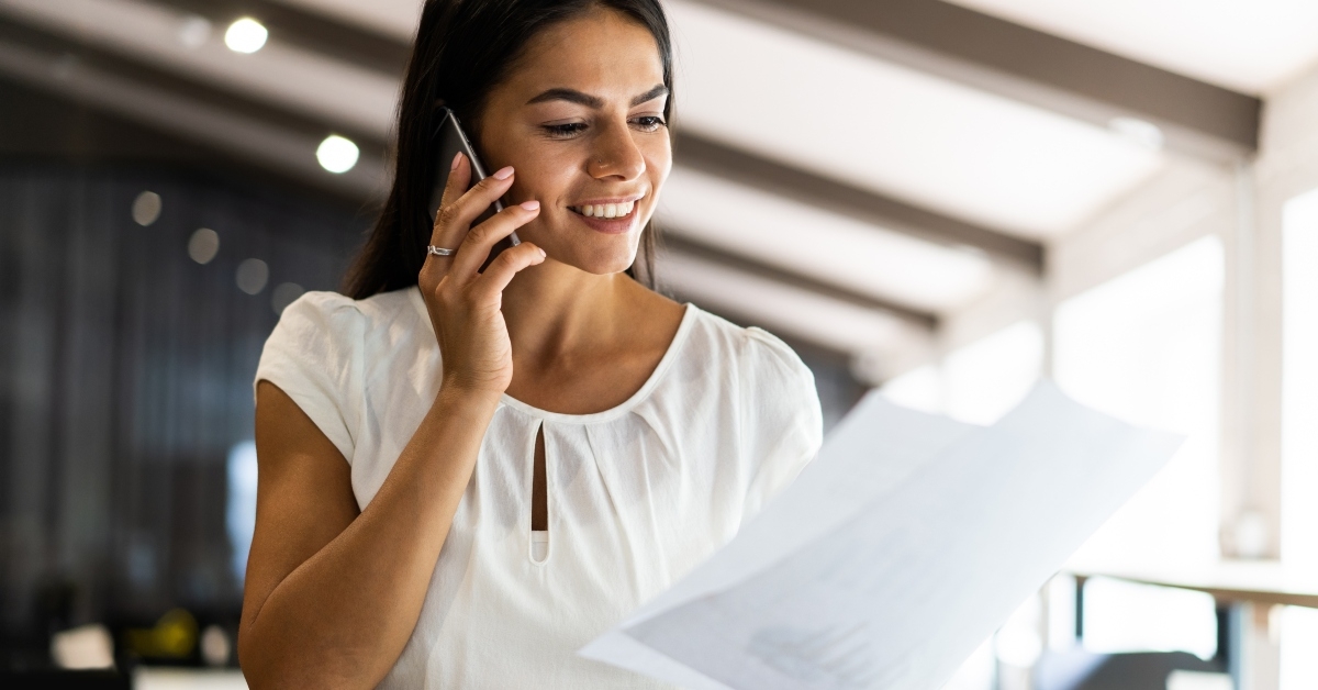 Woman on phone reading paperwork