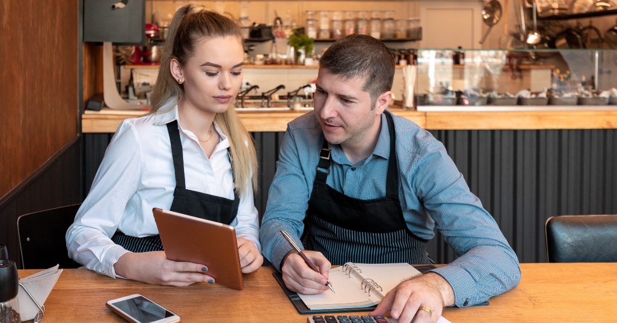 Man and woman at store calculating expenses