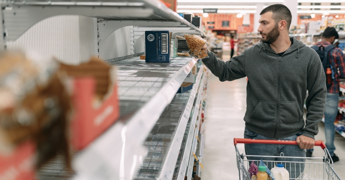 Man at store with almost empty shelves