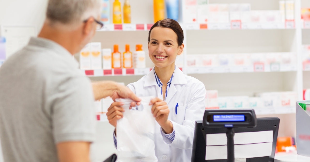 Pharmacist handing medicine to customer