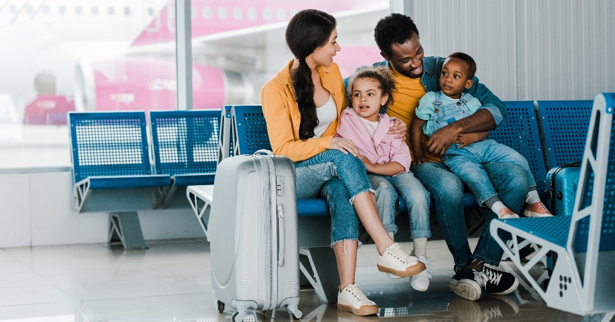 family with baggage and kids sitting in airport