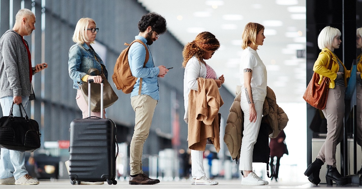 people standing in queue to check in at airport