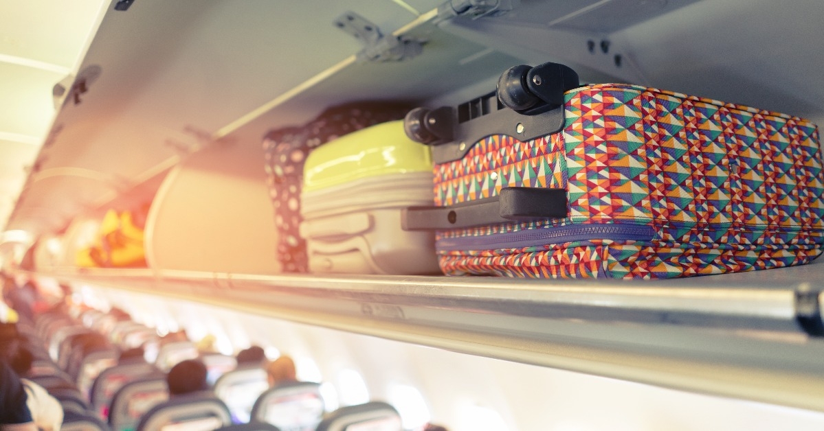 Carry-on luggage on the top shelf over head on airplane