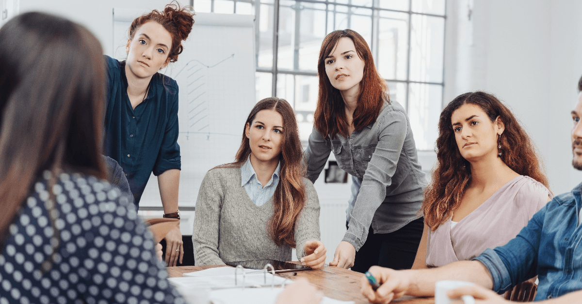 Group of young businesswomen listening attentively