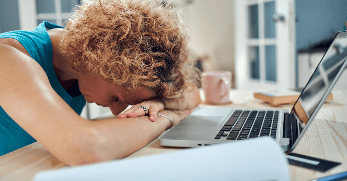 Woman sleeping on her desk at home while working remotely freelance job
