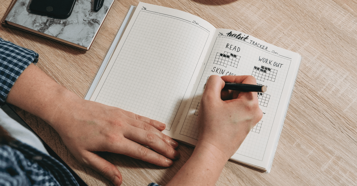 woman tracking habits in  bullet journal