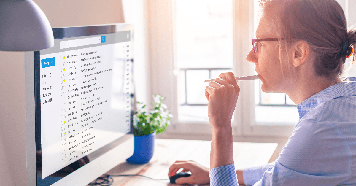 Female business person reading email on computer screen at work 