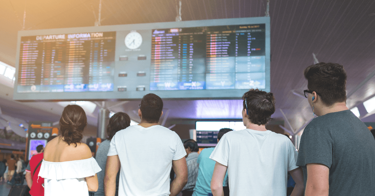 Young traveler in airport near flight timetable