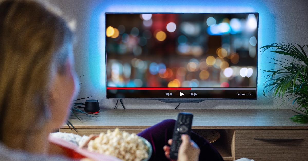Woman relaxing at home in evening and watching TV  