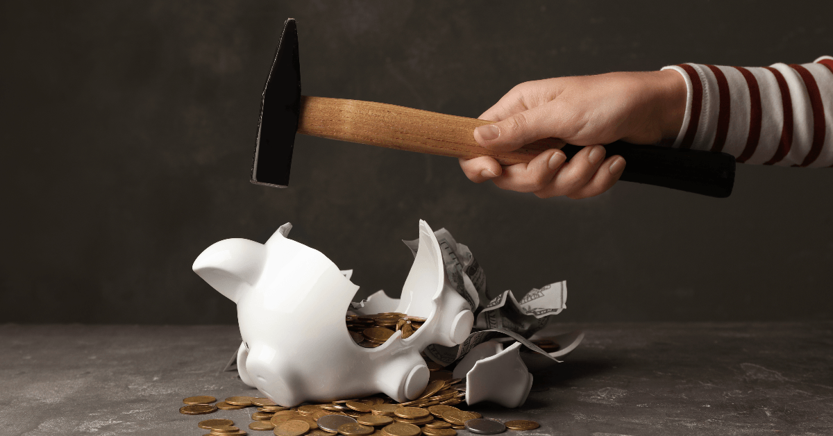 Breaking piggy bank with hammer