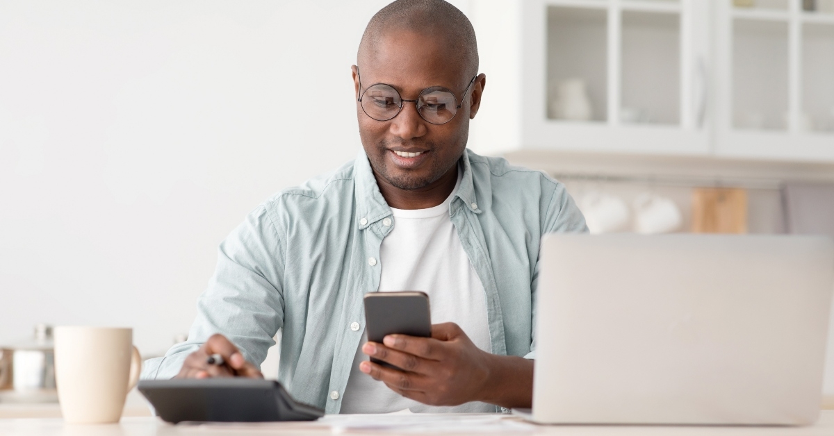 Man using phone and calculator