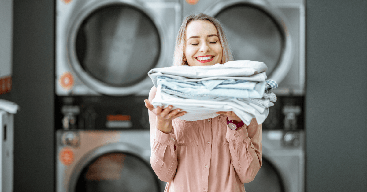woman holding pile of folded laundry