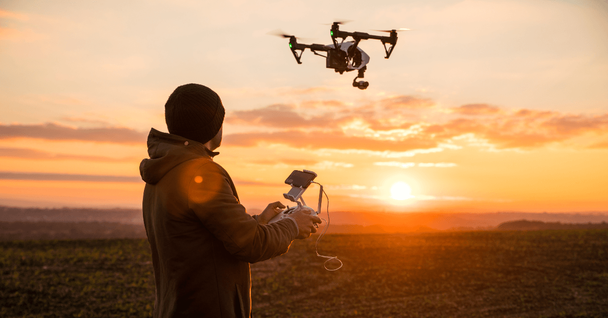 Person flying a drone at sunset
