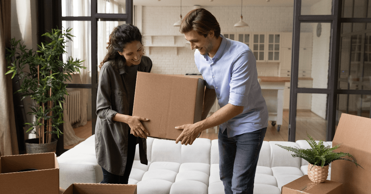 Couple unpacking boxes in house