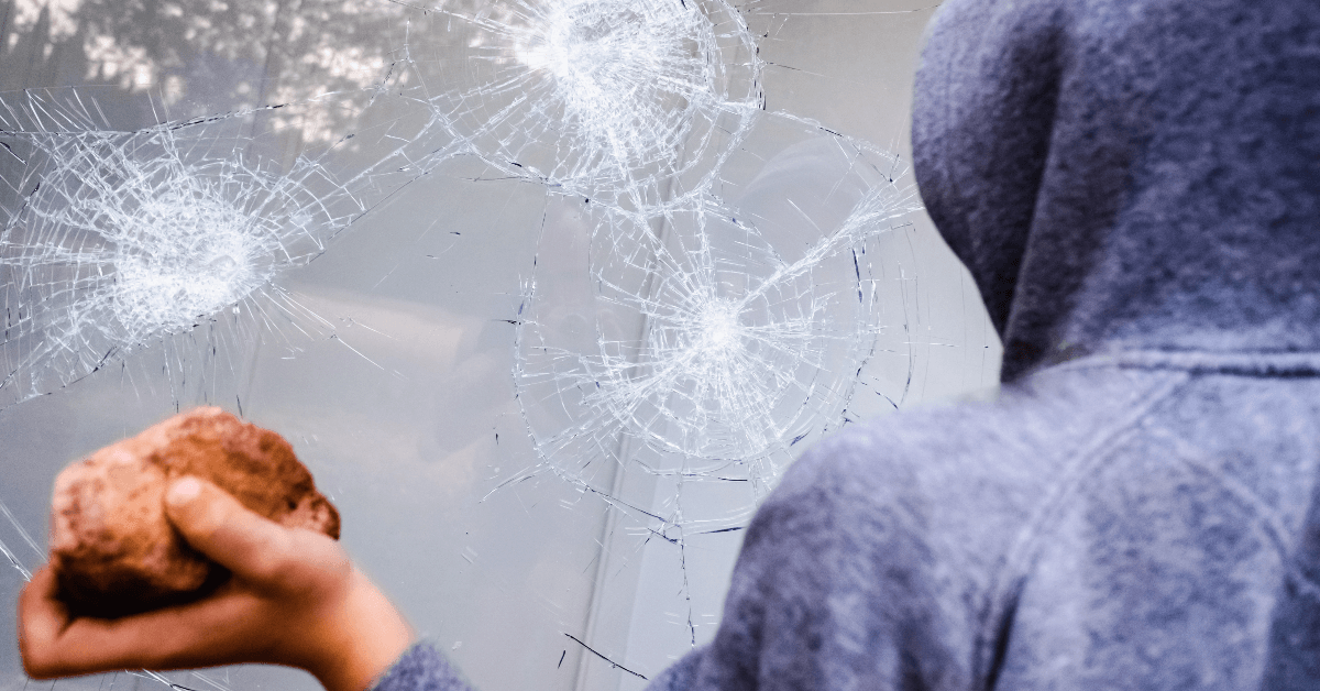 Boy throwing rock at window