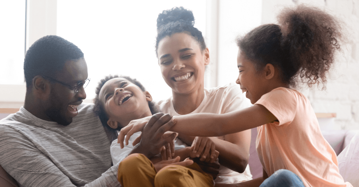 family laughing on couch