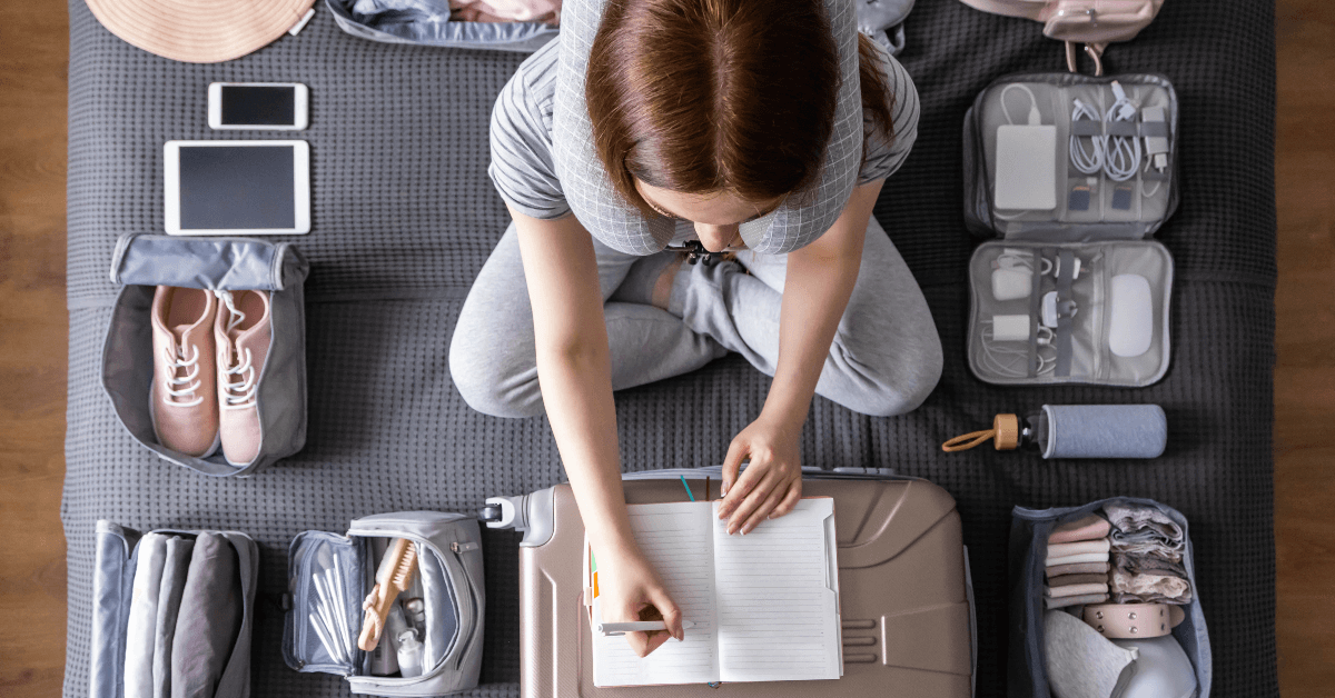 Woman packing suitcase and making list