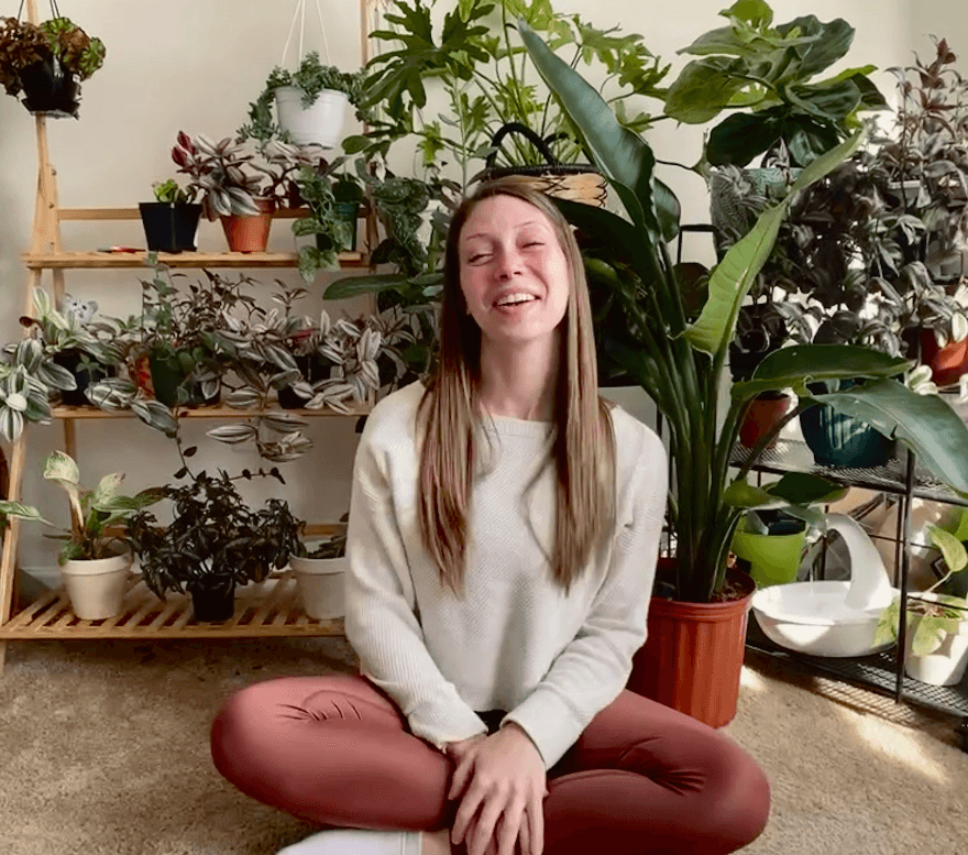 Happy woman sitting in front of plants