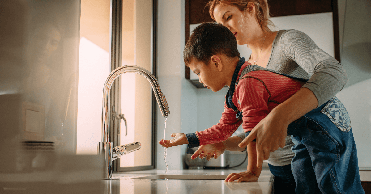 Mom helping son wash hands