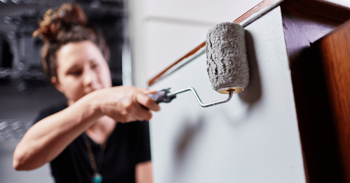 Woman painting cabinet
