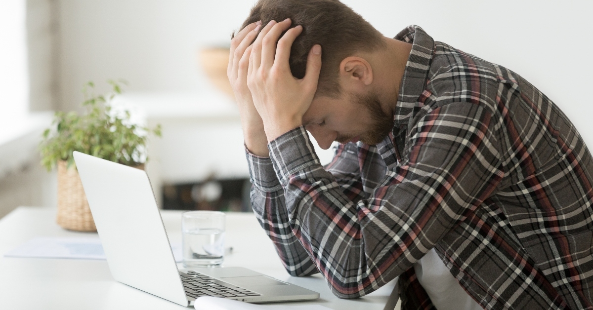 Frustrated depressed man holding head in hands