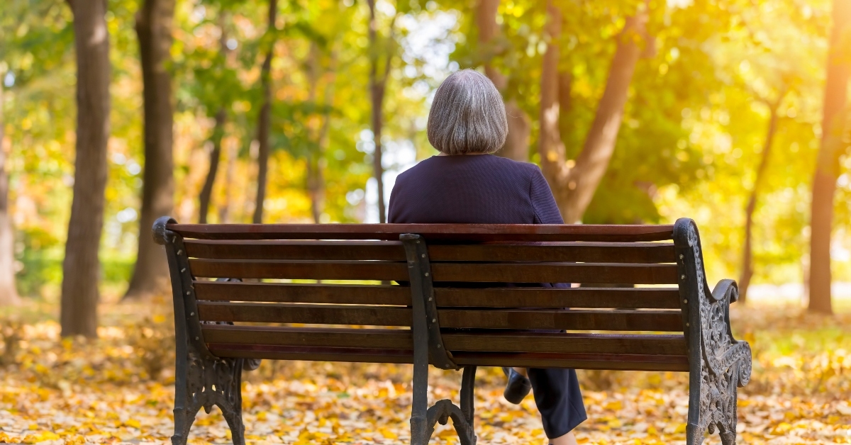 Senior woman sitting alone on a bench