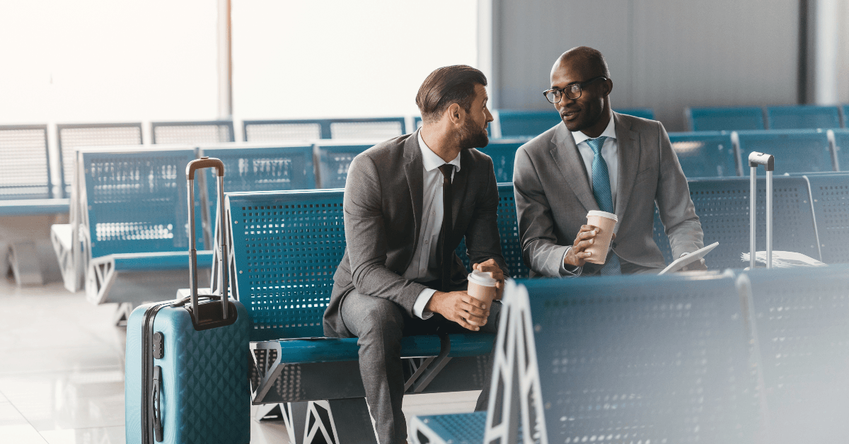 Two businessmen sitting and talking in airport