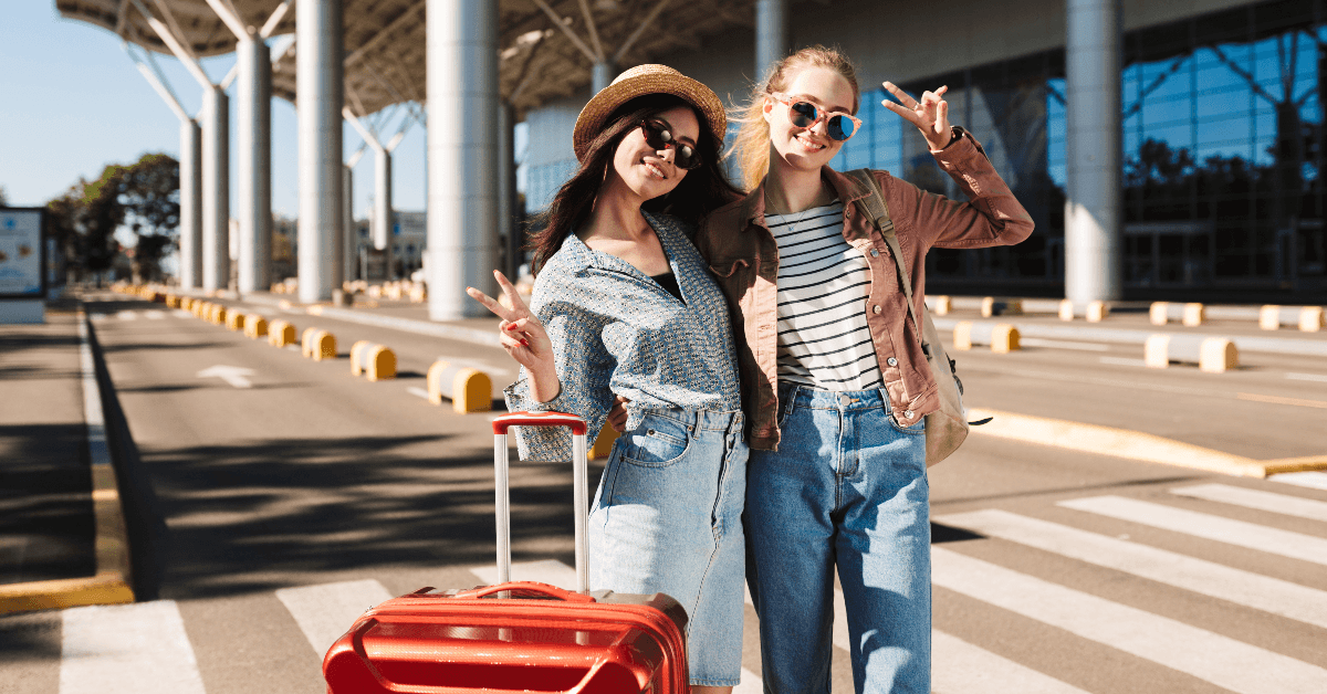 Happy women giving peace sign at the airport