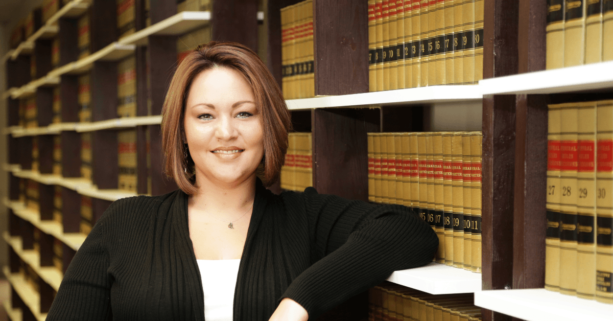 Law professor standing by library shelves