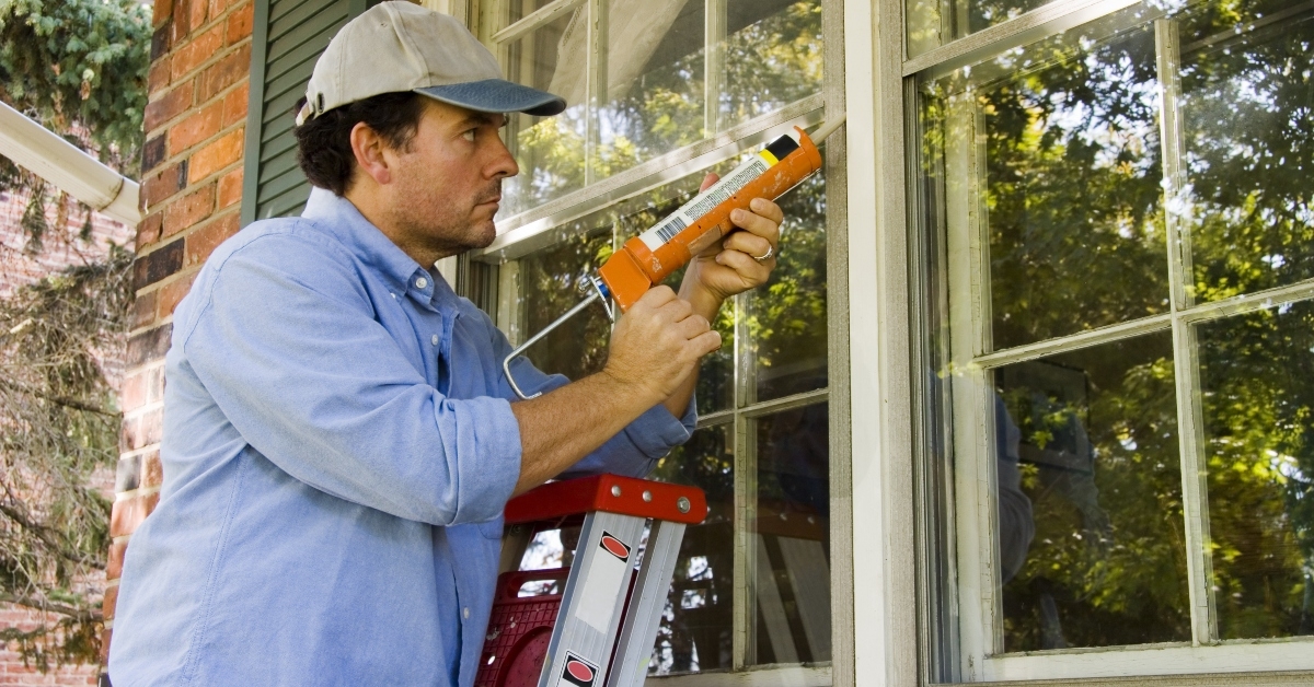 Man caulking window