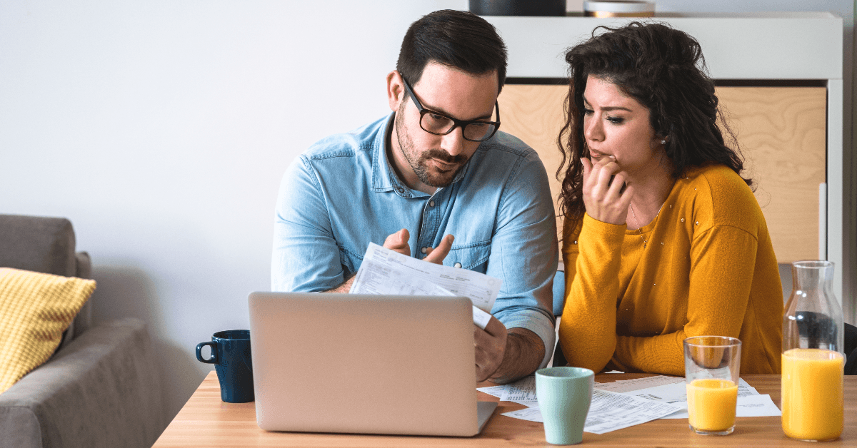 Couple looking at bills and computer