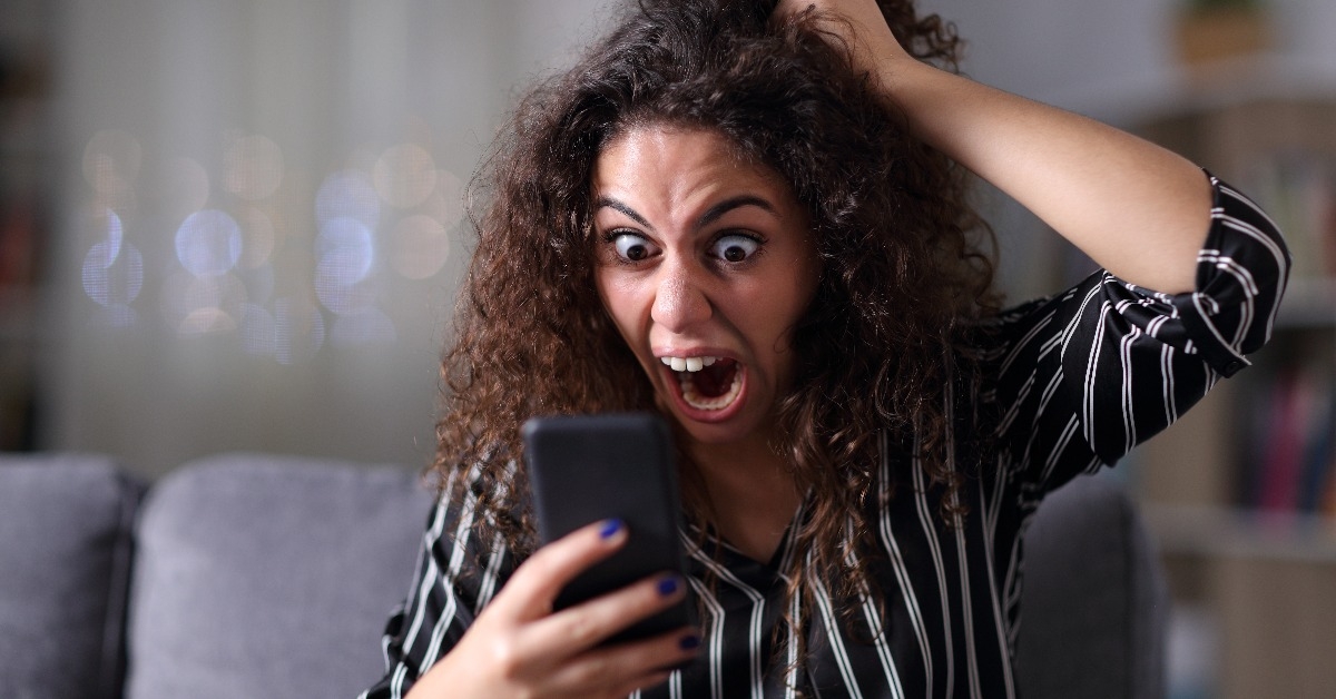 Woman yells at phone in excitement 