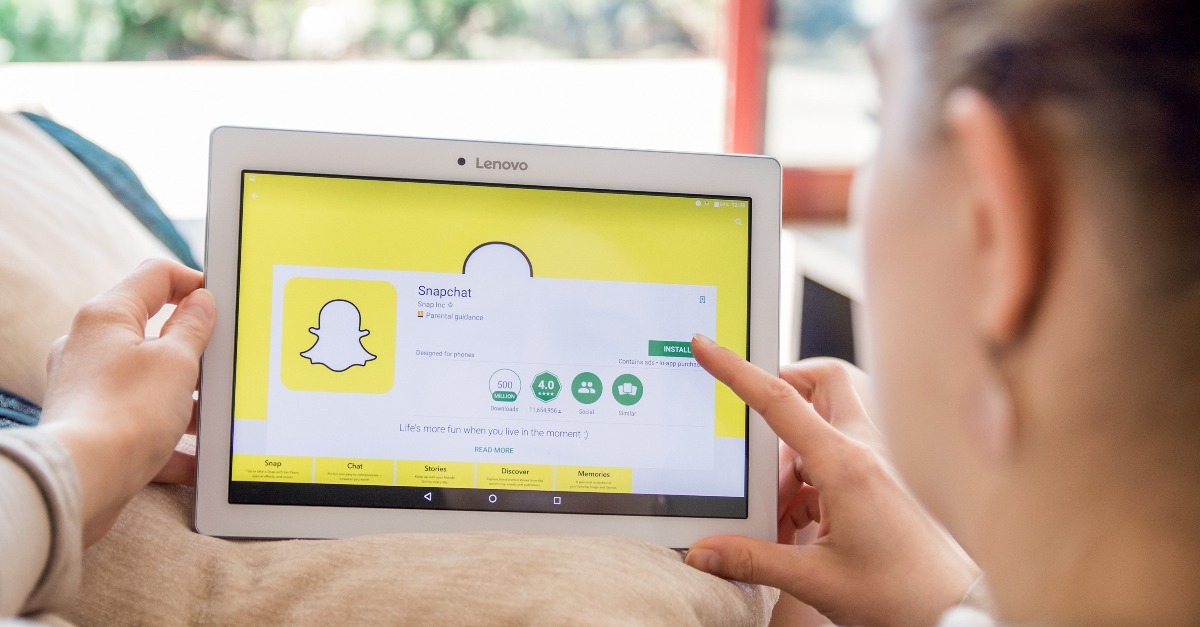 Woman is installing Snapchat application on Lenovo tablet