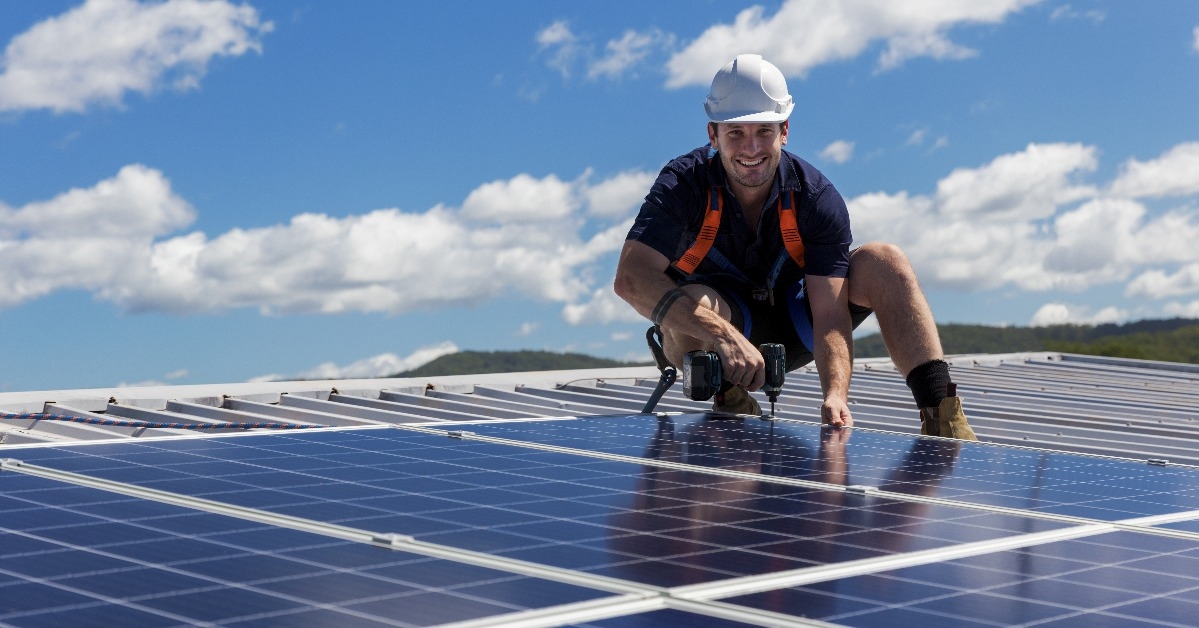 solar panel technician with drill installing solar panels